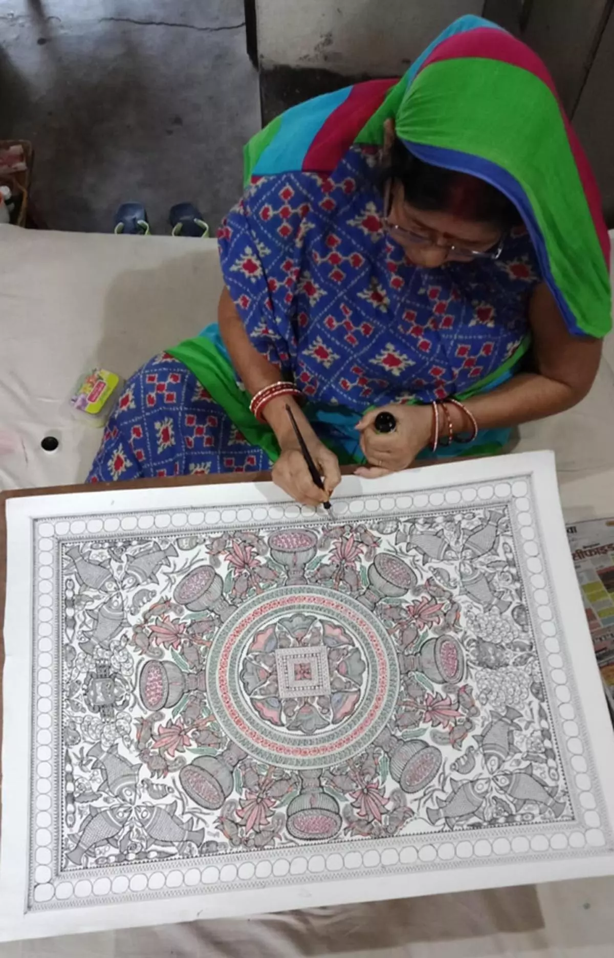 Kohbar art is now made on handmade paper. Bibha Das, a national award-winning Maithili painter, works on a drawing in Ranti.