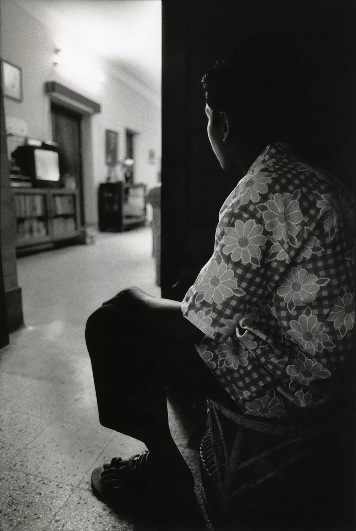 “Mizan”, 1996, Dhaka: Mizan, a domestic help, used to watch TV through the open doorway in the corridor, while the family for whom he worked sat inside. He could enter the room only for work. The day after the photo was published in the Drik calendar, Mizan sat inside to watch TV. Dhaka, Bangladesh.