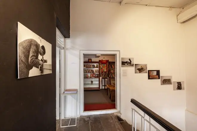 Photographs from Lhamo Tsering’s archives placed along walls and a view of a room with the section titled “Books from the Roof of the World” which make up parts of “Shadow Circus: A Personal Archive of Tibetan Resistance (1957-1974).” Photographs from Lhamo Tsering’s archives placed along walls and a view of a room with the section titled “Books from the Roof of the World” which make up parts of “Shadow Circus: A Personal Archive of Tibetan Resistance (1957-1974).”