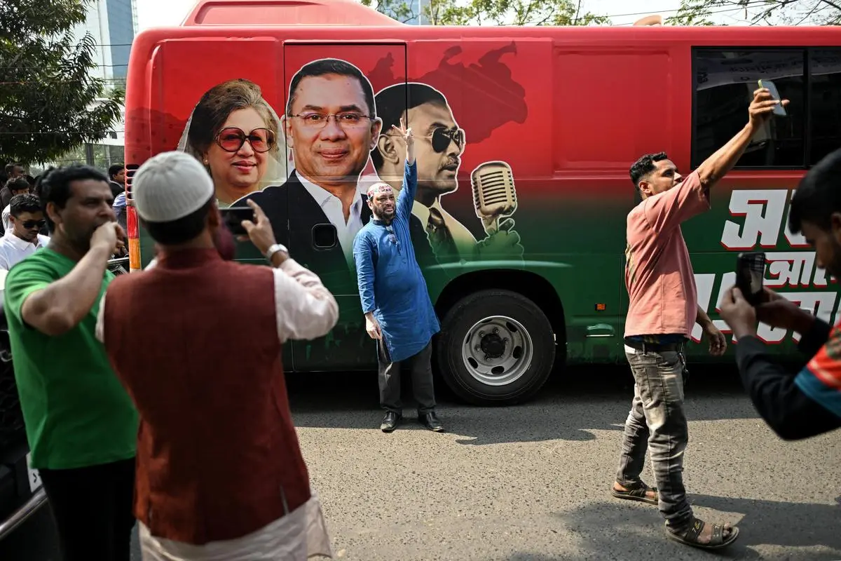 BNP supporters pose next to a bulletproof bus of Tarique Rahman during a rally on the final day of campaigning in Dhaka, on February 9.