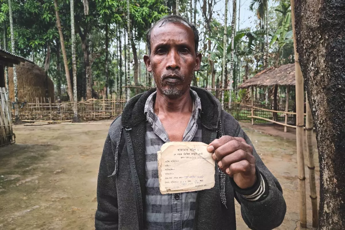 Jiten Murmu, an Adivasi farmer in Mikir Bamuni, shows “tax receipt” for the land in question.