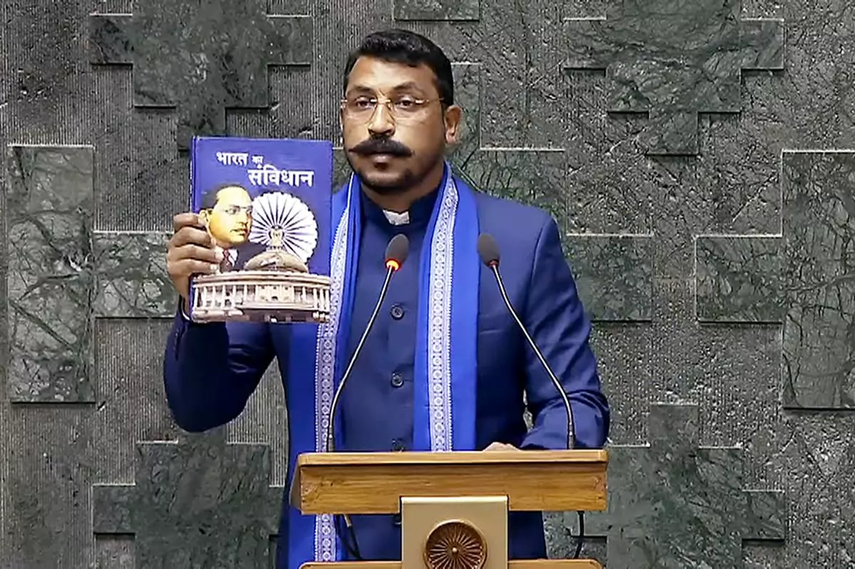 In July 2024, Chandrashekhar Azad introduced a private member Bill in the Lok Sabha for reservations in the private sector for SC/STs and OBCs. Here he holds up a copy of the Constitution while taking oath in the 18th Lok Sabha on June 25, 2024.