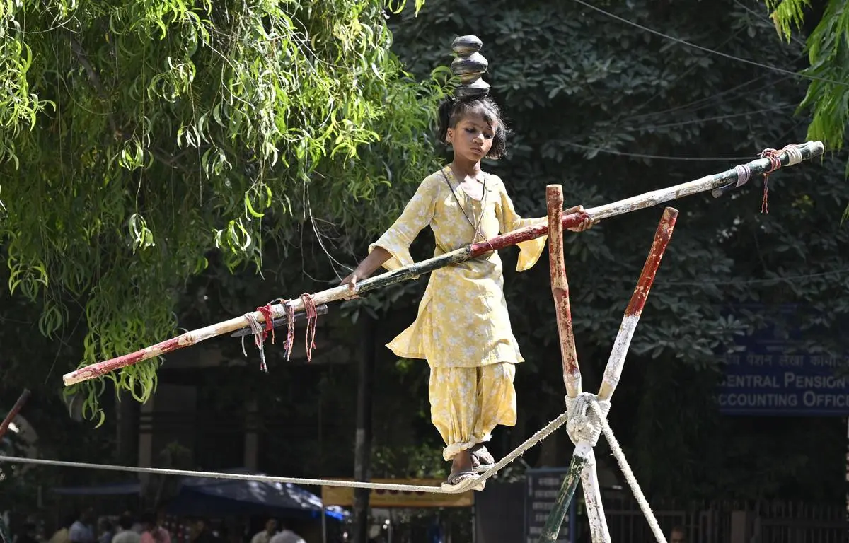 Of the nearly billion people in the working-age population, only a small minority—about 50 million—hold secure, formal employment. The rest circulate through low-productivity, low-wage work. Here, a girl performs street acrobatics in New Delhi on October 4, 2024.
