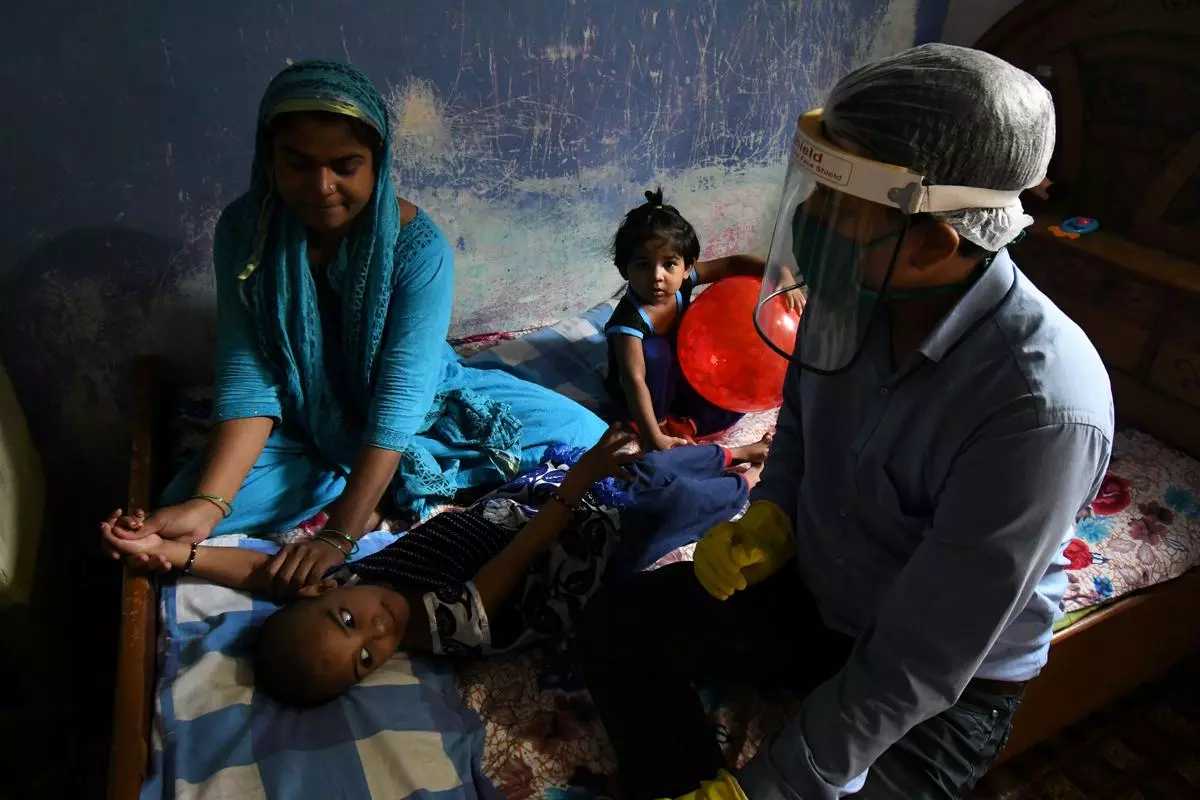 A therapist working with Mubshira who is affected by cerebral palsy as a result of being born to a parent affected by the Bhopal gas leak. The therapist goes door-to-door to offer therapy to the third-generation of disabled children affected by the Bhopal gas tragedy, in Bhopal on Sep 20, 2020.  