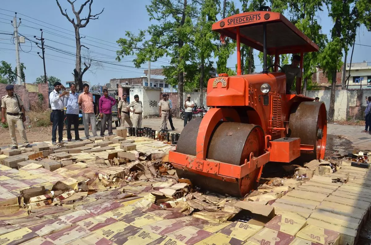 Seized bottles of liquor being destroyed in Patna.