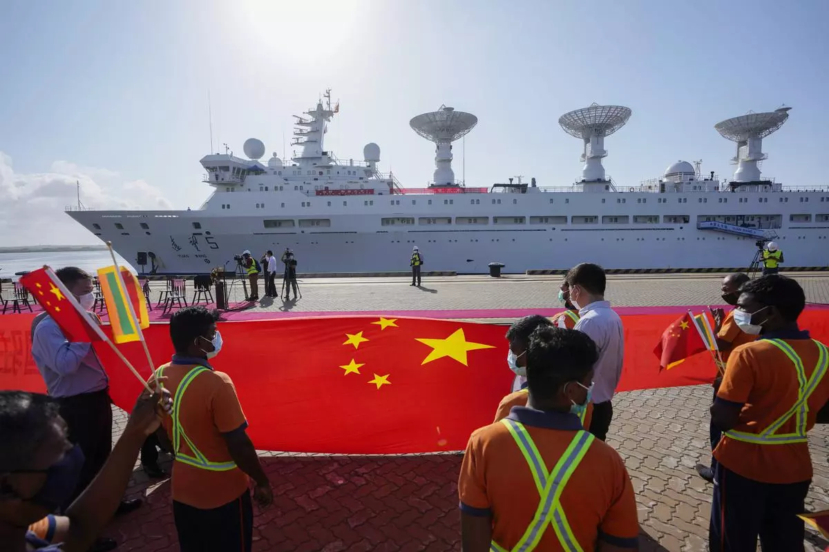Sri Lankan workers hold the Chinese flag to welcome the Chinese research ship Yuan Wang 5 as it arrives at Hambantota International Port in Sri Lanka in August 2022. China’s Belt and Road initiative has built power plants, roads, railroads, and ports around the world and deepened its relations with Africa, Asia, Latin America, and West Asia.