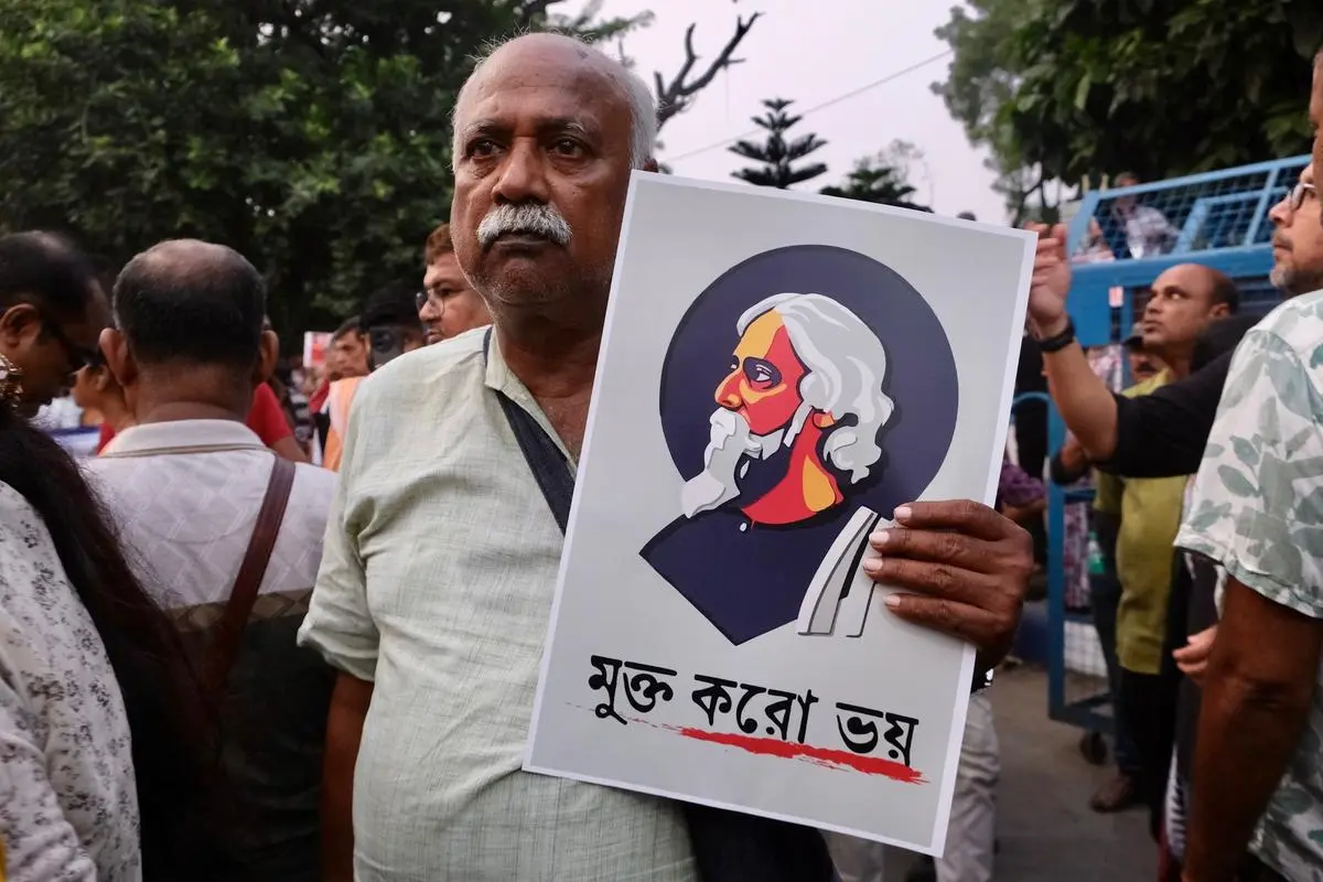 प्रोटेस्ट कार्निवल में एक व्यक्ति के हाथ में रवीन्द्रनाथ टैगोर का पोस्टर है जिस पर लिखा है, 