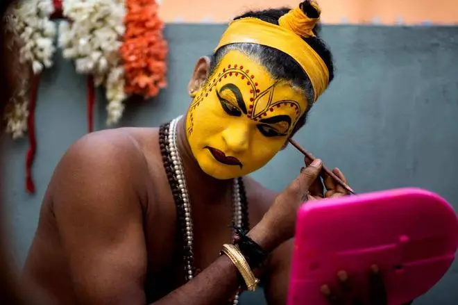 A Bhoota Kola artist puts on his makeup. A Bhoota Kola artist puts on his makeup.
