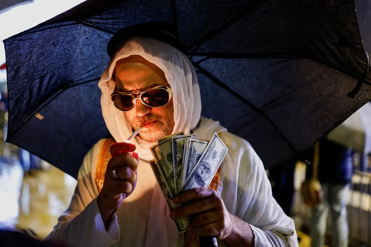 A protester holding mock dollar bills at a demonstration against Israeli Prime Minister Benjamin Netanyahu and his government, in Tel Aviv, on December 27, 2025.
