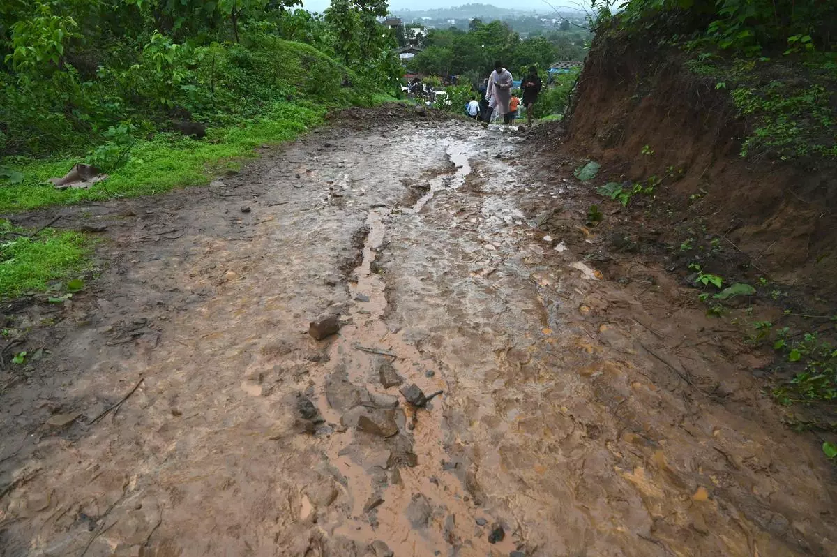 Rescue workers climb a mud track leading to the site of a landslide in Irshalwadi village.
