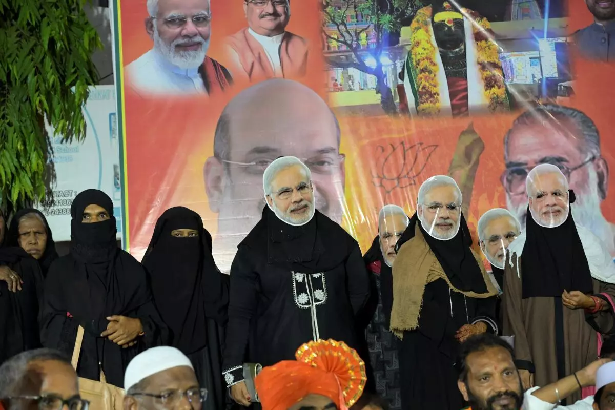 Muslim women wearing masks of Prime Minister Narendra Modi’s face during the Union Home Minister Amit Shah’s election campaign at Hyderabad on May 1, 2024. 