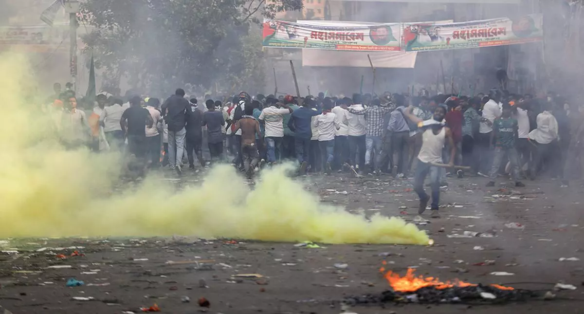 Bangladesh Nationalist Party activists run from tear gas shells fired by police during a protest in Dhaka, in October 2023, demanding the transfer of power to a non-partisan caretaker government to oversee the 2024 general election.