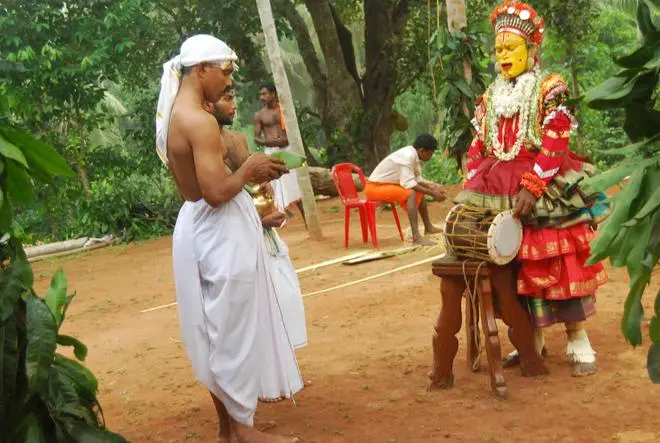 A Bhoota Kola artist visits a household. A Bhoota Kola artist visits a household.