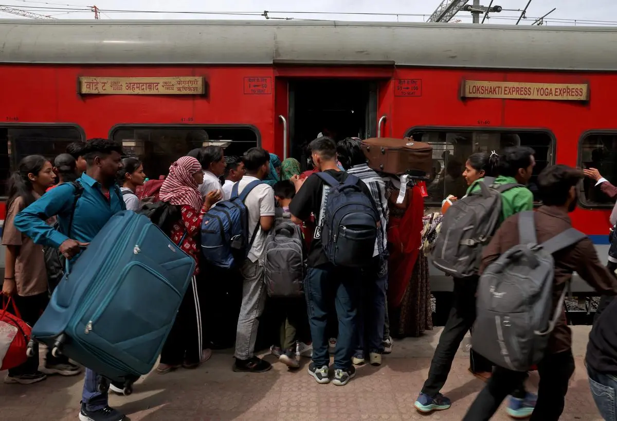 Migrant workers rush to board a train. They left for their hometowns amid LPG supply disruptions, in Ahmedabad on April 3.