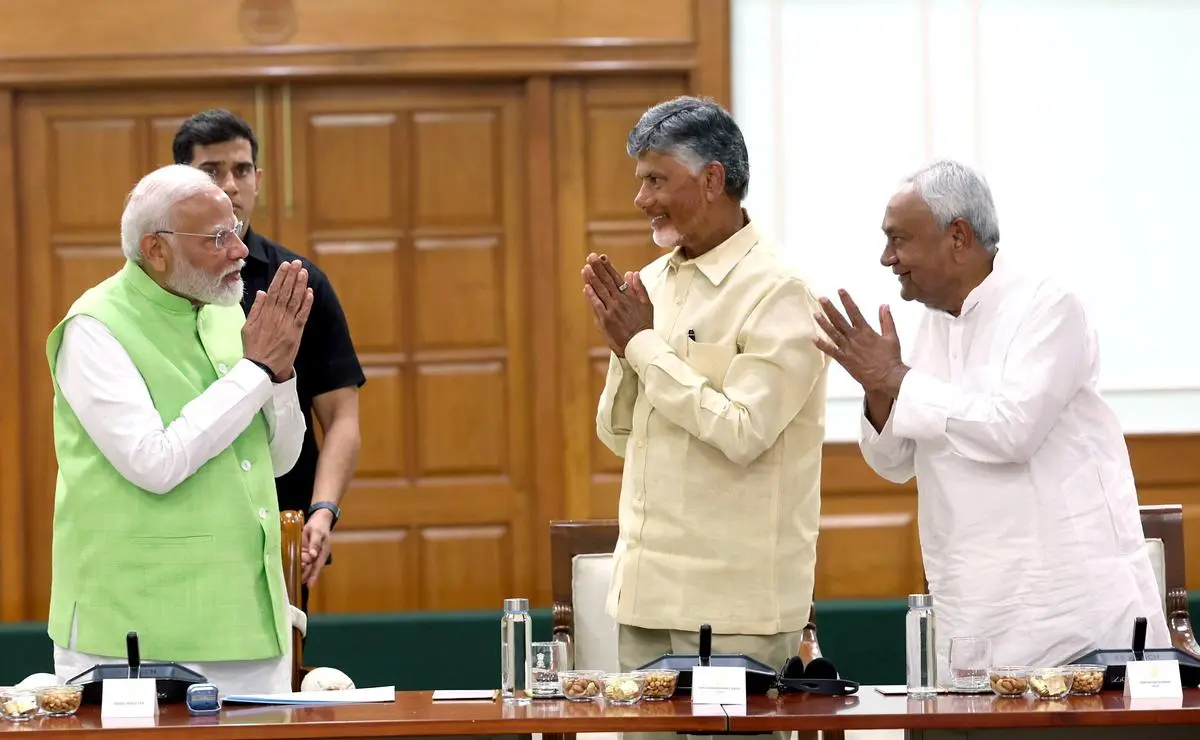 Prime Minister Narendra Modi greeting his alliance partners —Nitish Kumar of the JD(U) and N. Chandrababu Naidu of the TDP—during an NDA meeting at his residence, in New Delhi on June 5. 