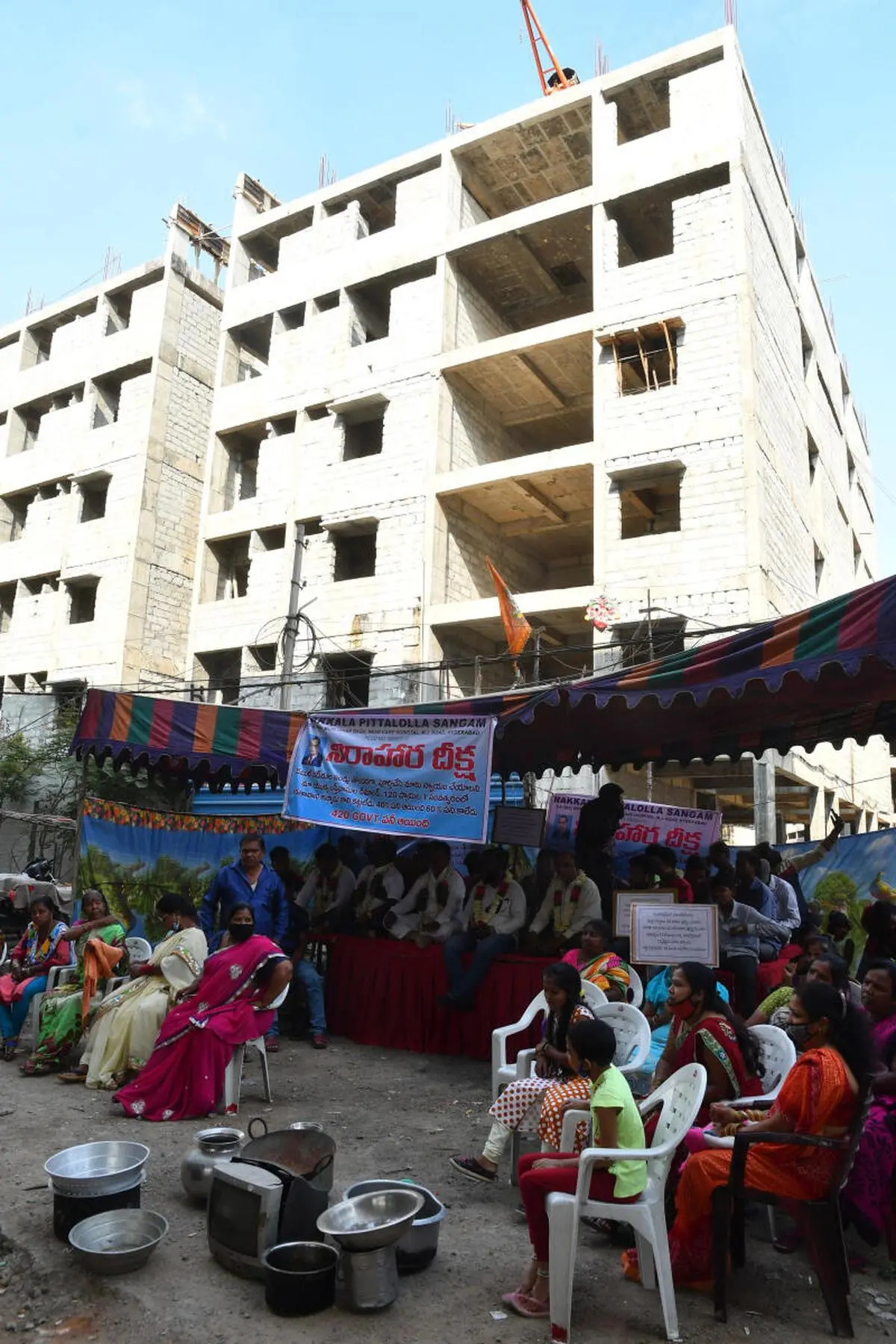 Beneficiaries of double-bedroom housing units protest at Murlidhar Bagh near CARE Hospital in Hyderabad, demanding completion of the construction and allotment under the Dignity Housing project. Slum dwellers had handed over their plots and shifted to rented accommodation upon promises towards 2BHK homes built in situ. 