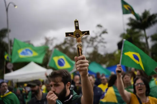A supporter of incumbent Brazilian President Jair Bolsonaro holds a crucifix during a protest against his defeat in the country’s presidential runoff, outside a military base in Sao Paulo on November 3. A supporter of incumbent Brazilian President Jair Bolsonaro holds a crucifix during a protest against his defeat in the country’s presidential runoff, outside a military base in Sao Paulo on November 3.
