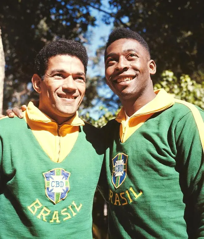 Brazilian footballer Pele (Edson Arantes do Nascimento) poses on right with Garrincha (Manuel Francisco dos Santos) both wearing Brazil national team uniform in 1962. Brazilian footballer Pele (Edson Arantes do Nascimento) poses on right with Garrincha (Manuel Francisco dos Santos) both wearing Brazil national team uniform in 1962.