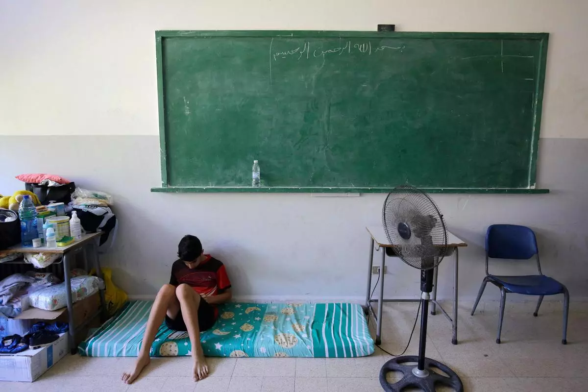 A displaced Lebanese sits inside a classroom at a school, housing displaced people in the town of Deir Ammar in northern Lebanon on October 17, 2024. 