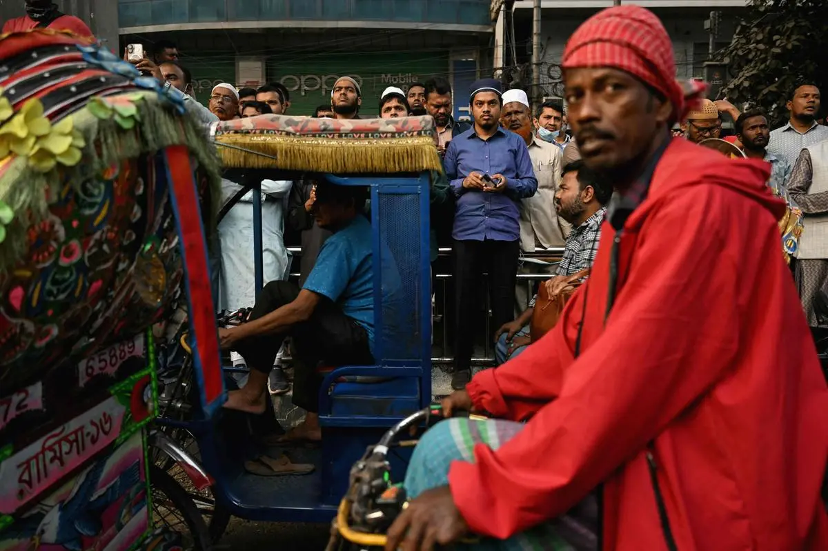 Passers-by and supporters watch a Jamaat-e-Islami party rally in Dhaka on February 16. 