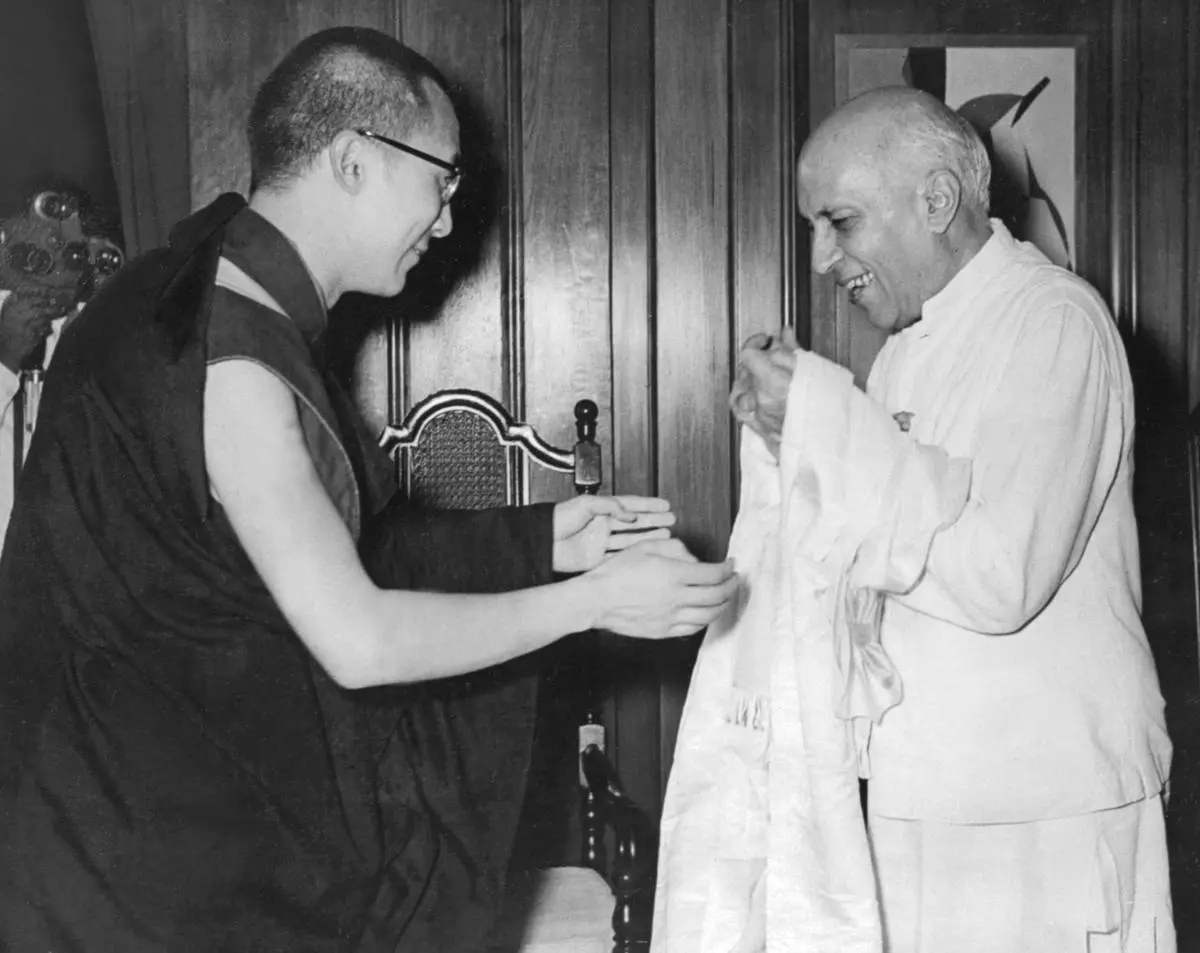 Sur cette photo prise le 7 septembre 1959, le Dalaï Lama offre une ceinture blanche tibétaine traditionnelle au Premier ministre indien de l’époque, Jawaharlal Nehru, à New Delhi, lors de sa première visite à Nehru depuis son arrivée en exil en 1959. 