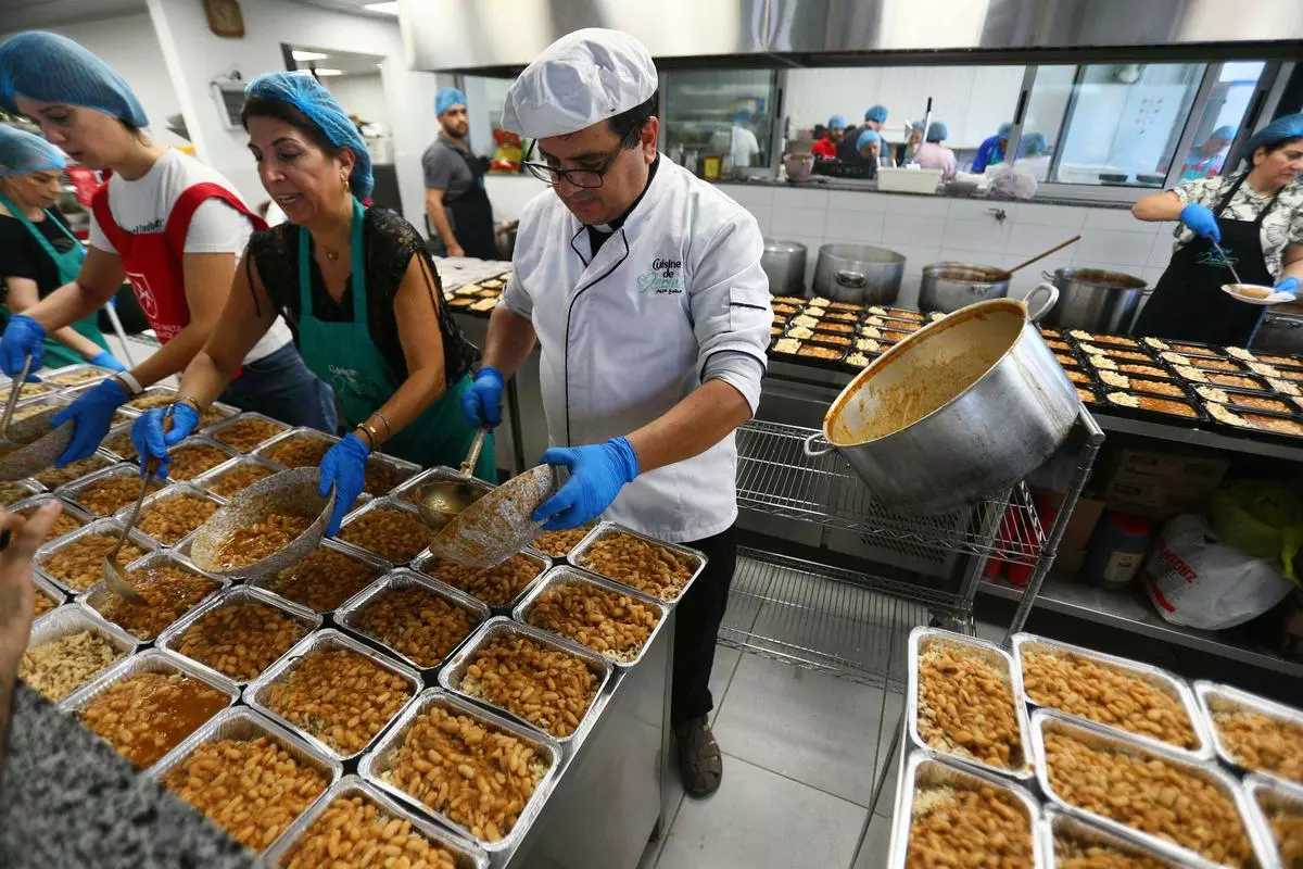 Father Hani Tawk supervises the preparation of food for displaced people at a charitable facility in Beirut on October 17, 2024.