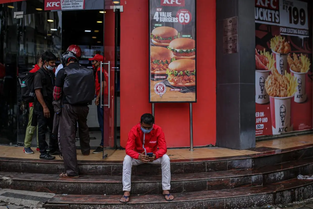 A Zomato delivery agent waits to collect an order from a KFC restaurant in Mumbai, in July 2021. Gig work is casual and likely to be unstable depending on the effective demand for these services. A Zomato delivery agent waits to collect an order from a KFC restaurant in Mumbai, in July 2021. Gig work is casual and likely to be unstable depending on the effective demand for these services.