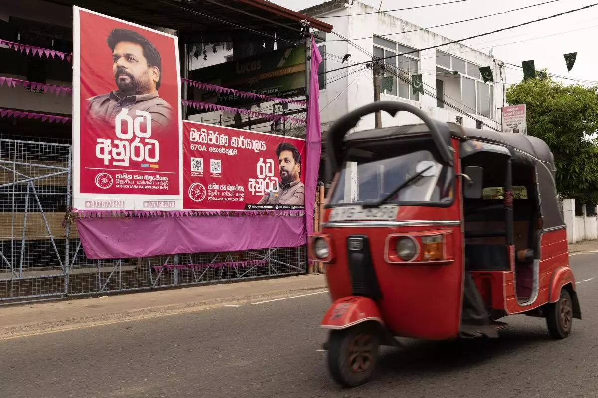 Auto-rickshaw drives past the election campaign billboard of Anura Kumara Dissanayake, presidential candidate of National People’s Power (NPP) party on September 15, 2024 in Colombo, Sri Lanka. 