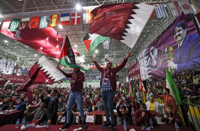 Palestinian football fans wave national and Qatari flags as they watch a live broadcast of the 2022 World Cup opening match between Qatar and Ecuador, at a covered gymnasium in Gaza city, on November 20. Palestinian football fans wave national and Qatari flags as they watch a live broadcast of the 2022 World Cup opening match between Qatar and Ecuador, at a covered gymnasium in Gaza city, on November 20.