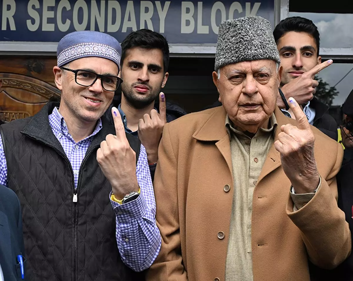 National Conference President Farooq Abdullah and his son former Jammu and Kashmir Chief Minister Omar Abdullah show their inked fingers after casting their votes.