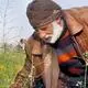 An elderly Palestinian man picks flowers from a field next to building rubble, ahead of the iftar fast-breaking meal during the Muslim holy month of Ramadan, in their tent at the Bureij refugee camp in the central Gaza Strip on March 5, 2025.
