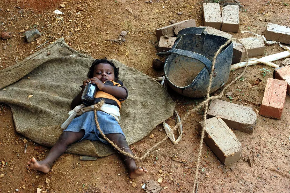 A baby rests while his parents work in a brick manufacturing unit in Thrissur district, Kerala; a file photograph. Nutrition for children of working class families continues to be a concern. 