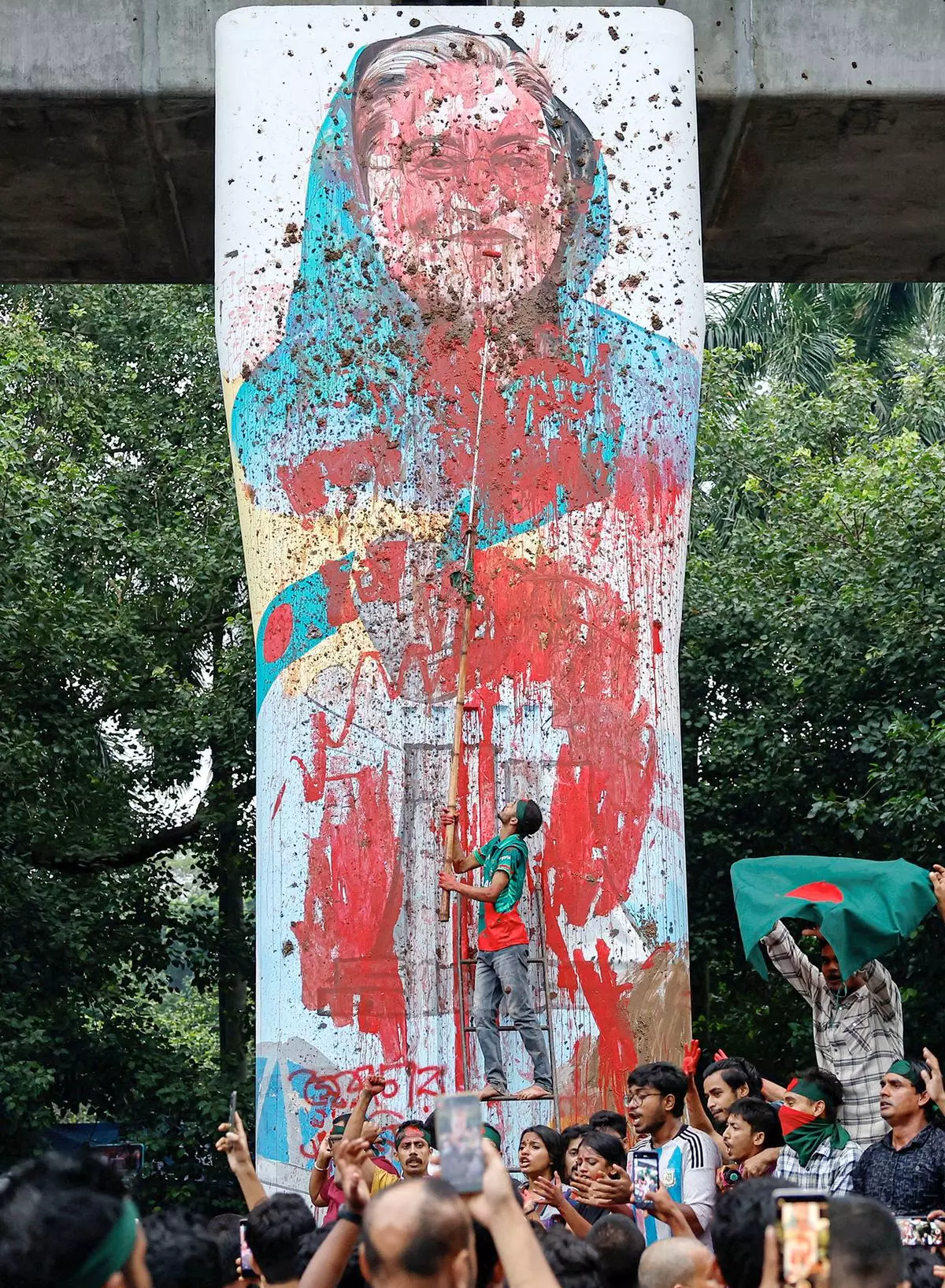 Protesters shout slogans as they vandalise a mural of Sheikh Hasina with paint and mud at Teacher Student Center (TSC) area of University of Dhaka in Dhaka, Bangladesh on August 3, 2024. 