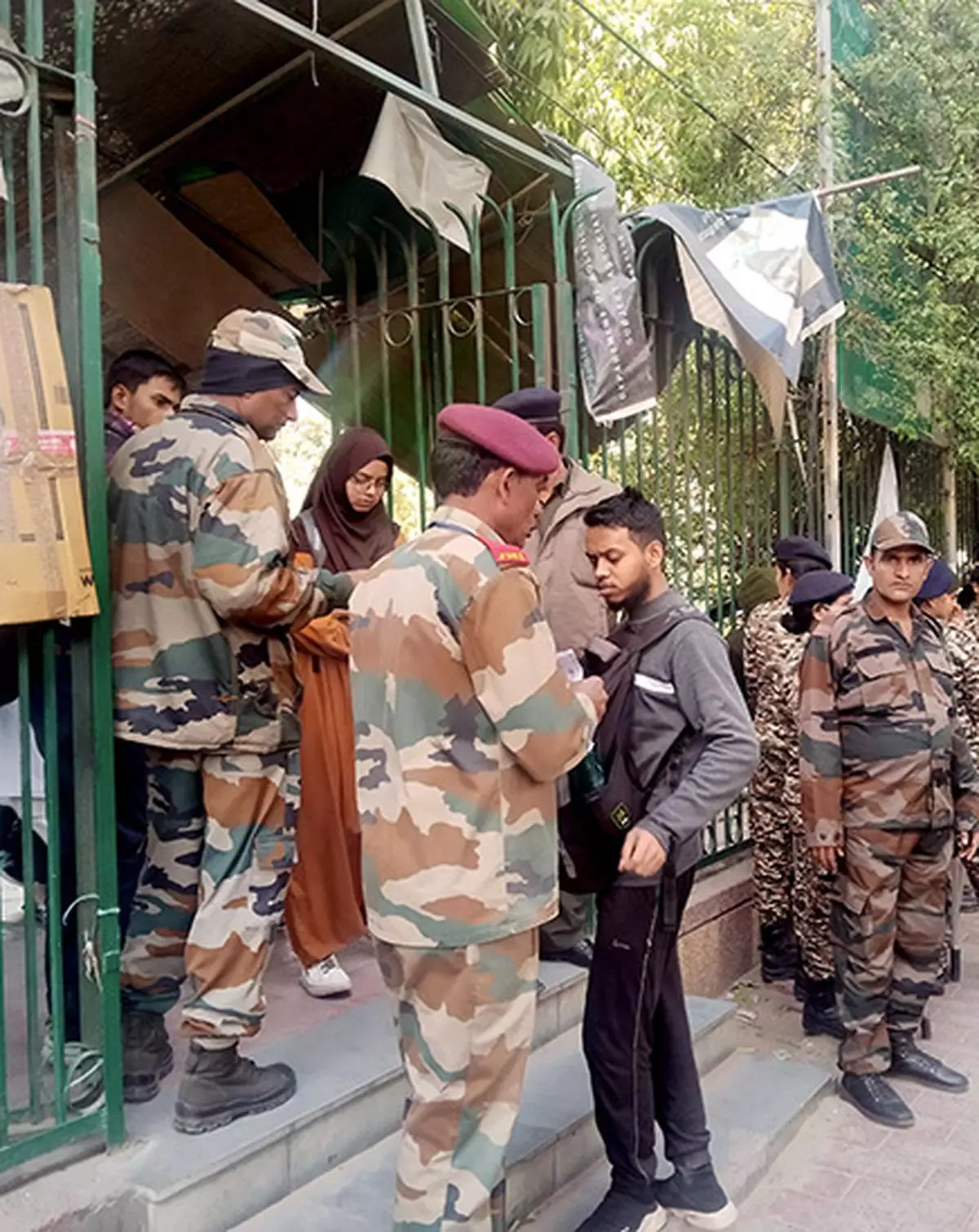 Security personnel check a student’s ID amid tight security outside Jamia Millia Islamia after several students were detained by Delhi Police in the early hours of February 13 for protesting against the university’s disciplinary action against two PhD scholars.