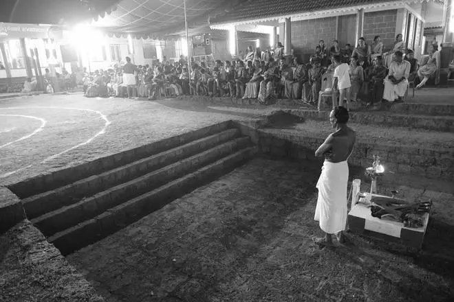A man belonging to the Mavilan community waits outside the Kakkat Mahavishnu Temple for the vilaku to start his Theyyam. A man belonging to the Mavilan community waits outside the Kakkat Mahavishnu Temple for the vilaku to start his Theyyam.