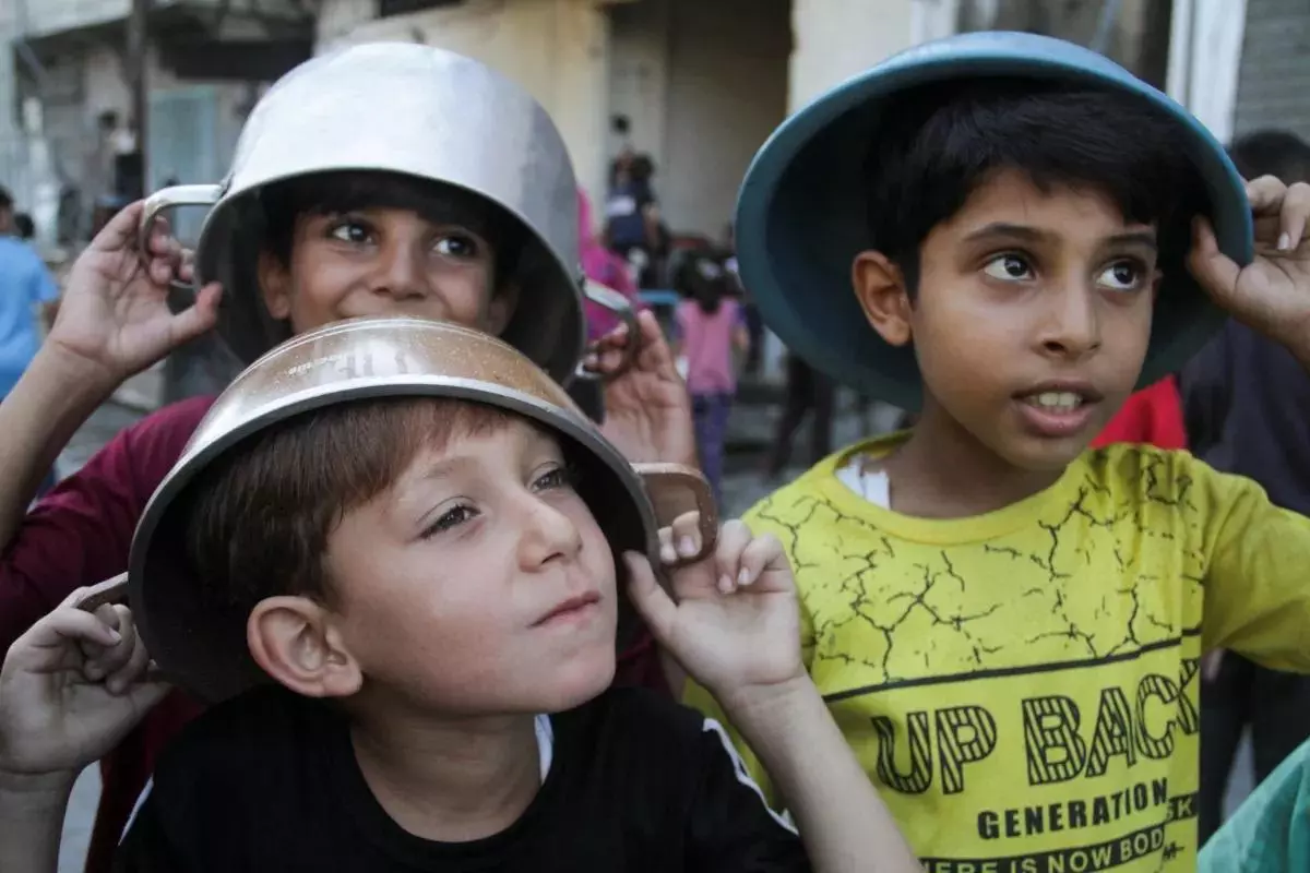 Palestinian children wait to receive food as conflict between Israel and Hamas continues, in the northern Gaza Strip on August 14.