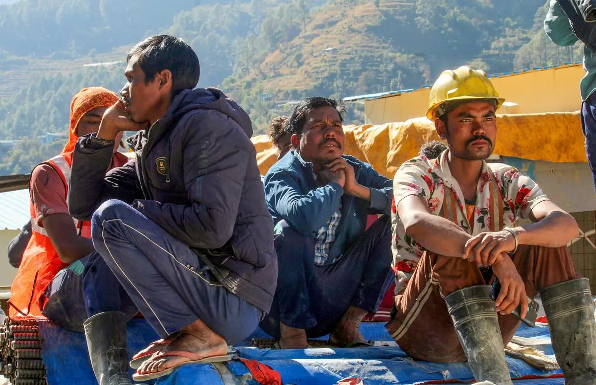 Local people and family members of trapped workers wait for news near the under-construction tunnel, days after a portion of the tunnel collapsed. November 22, 2023.