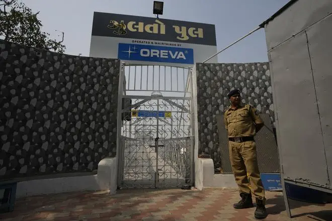 A policeman stands guard next to an entrance to the Morbi bridge. A policeman stands guard next to an entrance to the Morbi bridge.