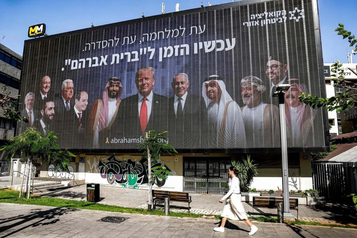 A billboard in Tel Aviv, seen on June 26, shows the leaders of Jordan, Lebanon, Syria, Egypt, Saudi Arabia, UAE, Oman, Morocco, and Bahrain along with Donald Trump, Benjamin Netanyahu, and Mahmoud Abbas, with a line in Hebrew: “A time for war, a time for settlement; now is the time for the ‘Abrahamic Covenant’.”  