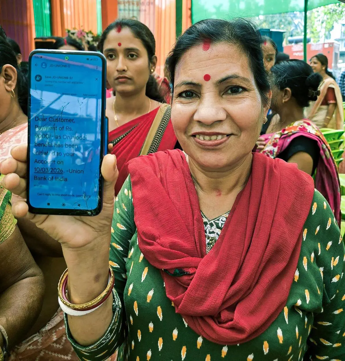 A woman shows the credited amount under the Orunodoi scheme, in Guwahati, on March 10.