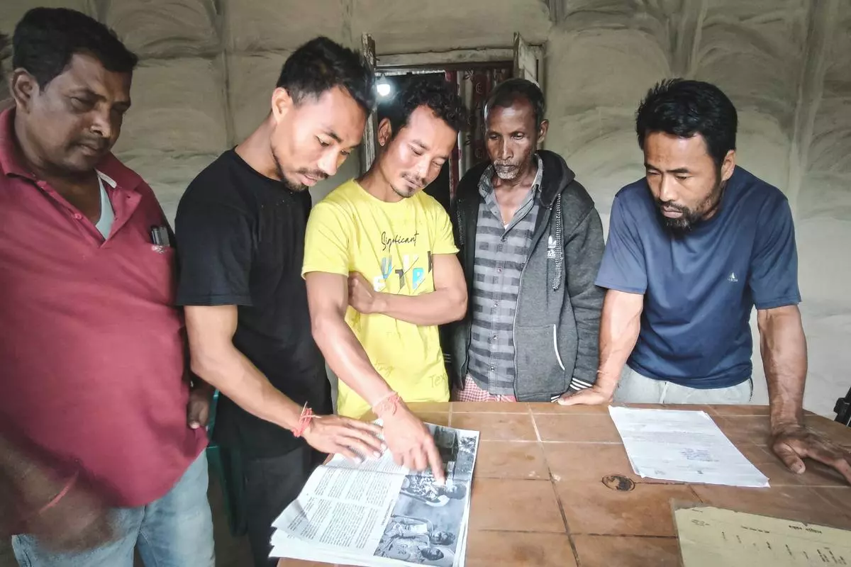 A group of affected villagers in Mikir Bamuni read out the issues mentioned in a fact-finding report.