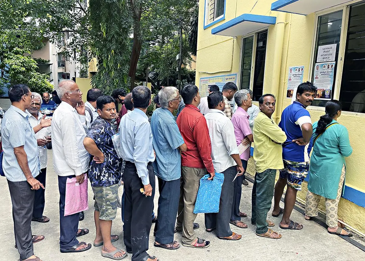 लोग 19 जून, 2023 को बेंगलुरु में ग्रुहा ज्योति (फ्री पावर) योजना के लिए पंजीकरण करने का इंतजार करते हैं। इस तरह की कल्याणकारी योजनाएं राज्य सरकार पर वित्तीय तनाव पैदा कर रही हैं।