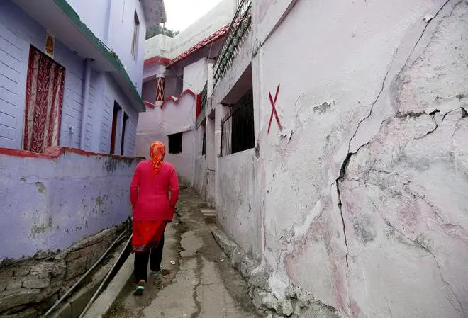 A resident near a house marked with a red cross after land subsidence, in Joshimath on January 12. A resident near a house marked with a red cross after land subsidence, in Joshimath on January 12.