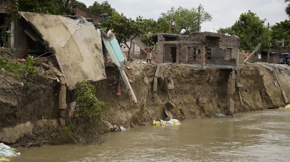 The remains of the houses destroyed by river erosion hanging over the waters.  