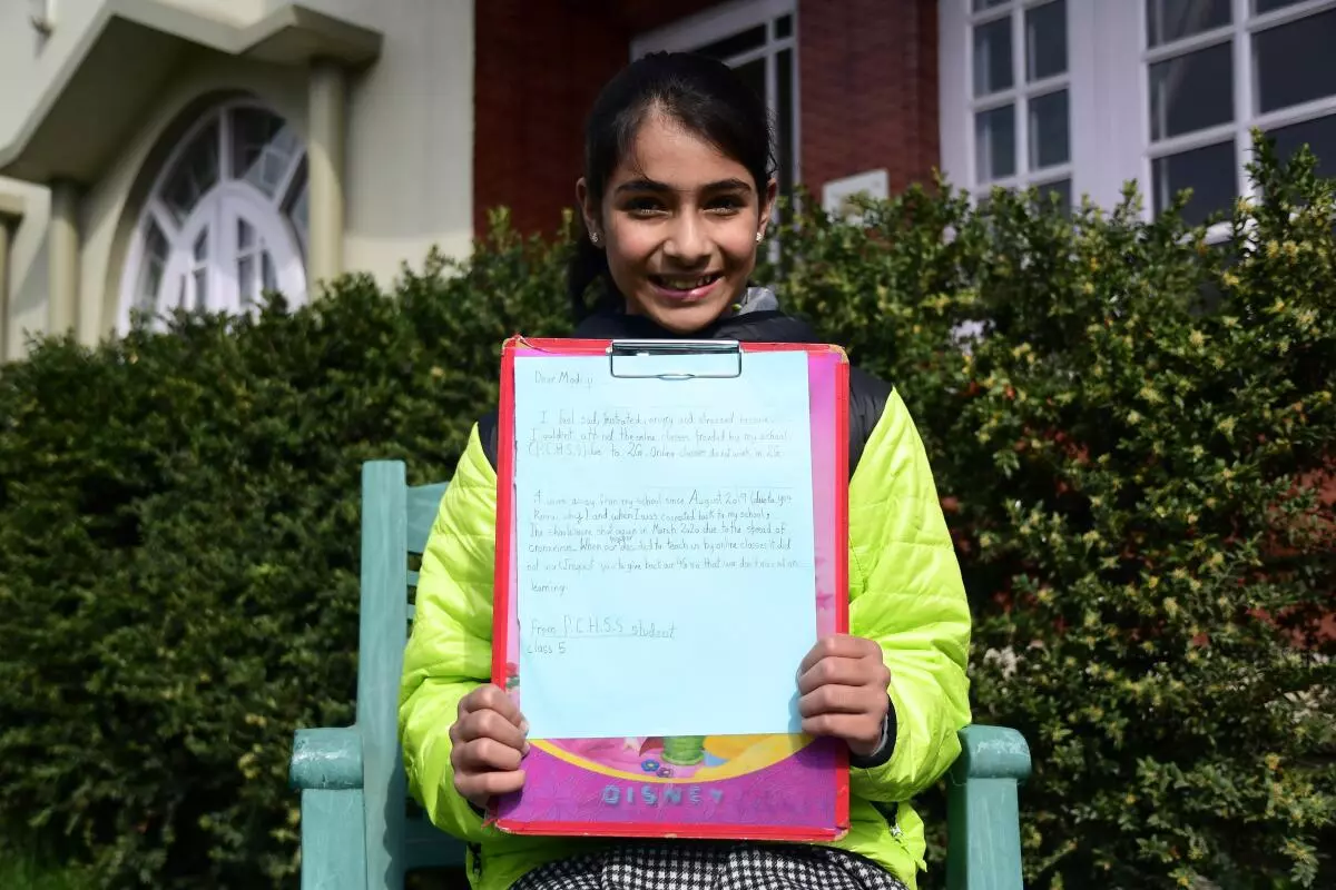 Hiba Arjumamd Wani, a class V school student holds her letter addressed to PM Modi demanding restoration of 4G internet services in Kashmir on grounds that it is affecting online education on March 31, 2020, at the start of the COVID-19 lockdown. 