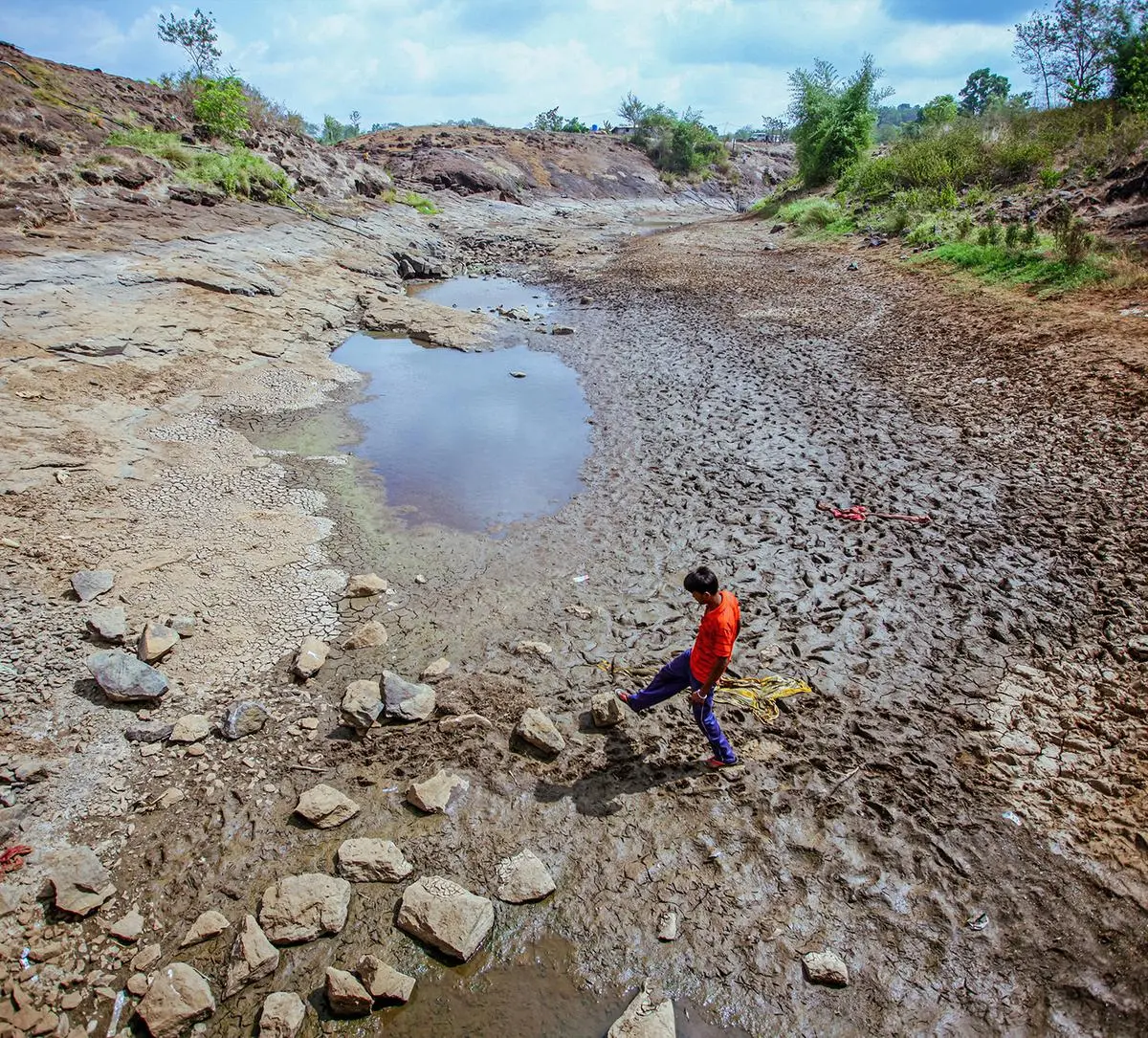 A man crosses the dry and cracked bed of the Koparli dam on May 26, 2023. A man crosses the dry and cracked bed of the Koparli dam on May 26, 2023.