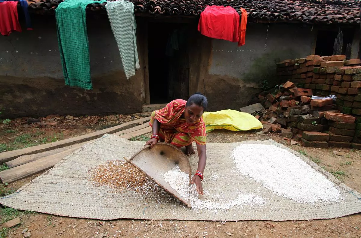 A woman cleans puffed rice outside her home in a village in Debagarh district of Odisha in 2017.