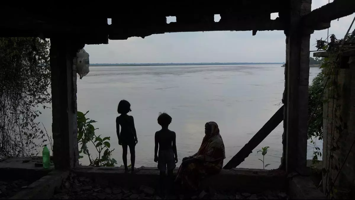 Radharani with her grandchildren in the broken house of her son.