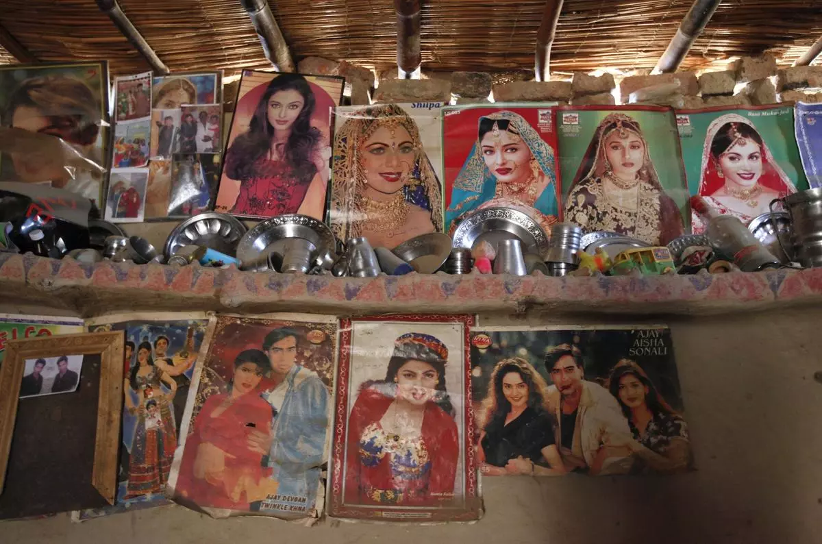 A mud wall shelf adorned with Bollywood film star posters in a room owned by a cotton picker’s family in Meeran Pur village, north of Karachi November 23, 2014.