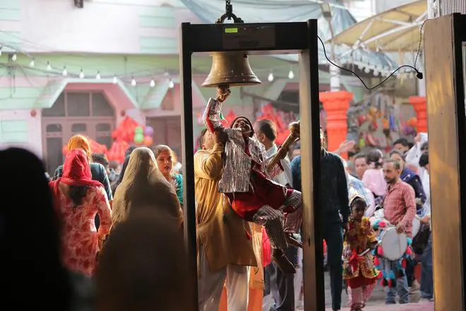 A child dressed as a langur rings the temple bell with a little help, at the Bada Hanuman temple situated just outside the old walled city of Amritsar. A child dressed as a langur rings the temple bell with a little help, at the Bada Hanuman temple situated just outside the old walled city of Amritsar.